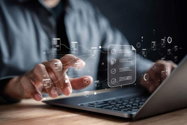 Hands using a laptop to review digital documents